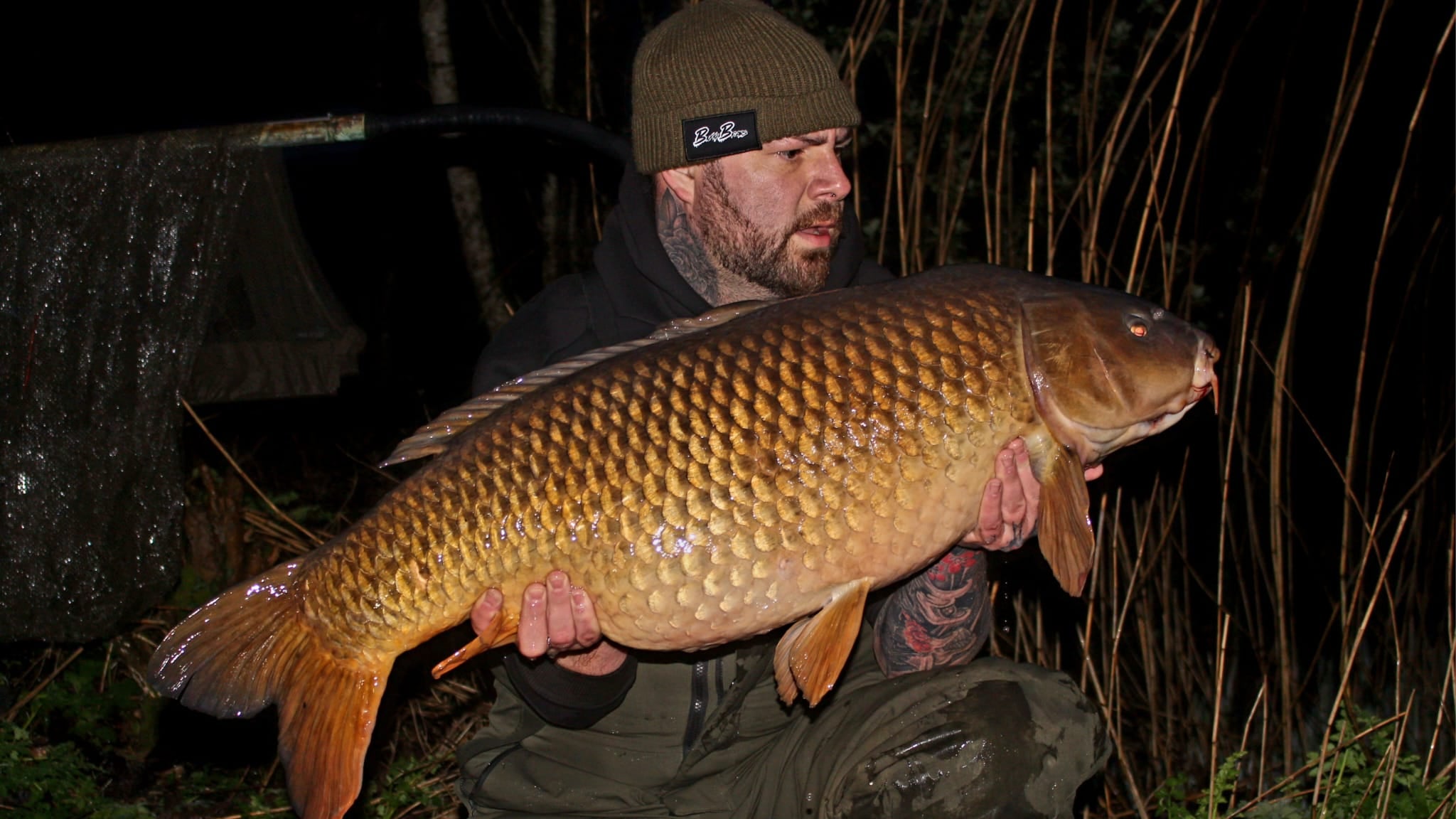 Man holding a large fish at night